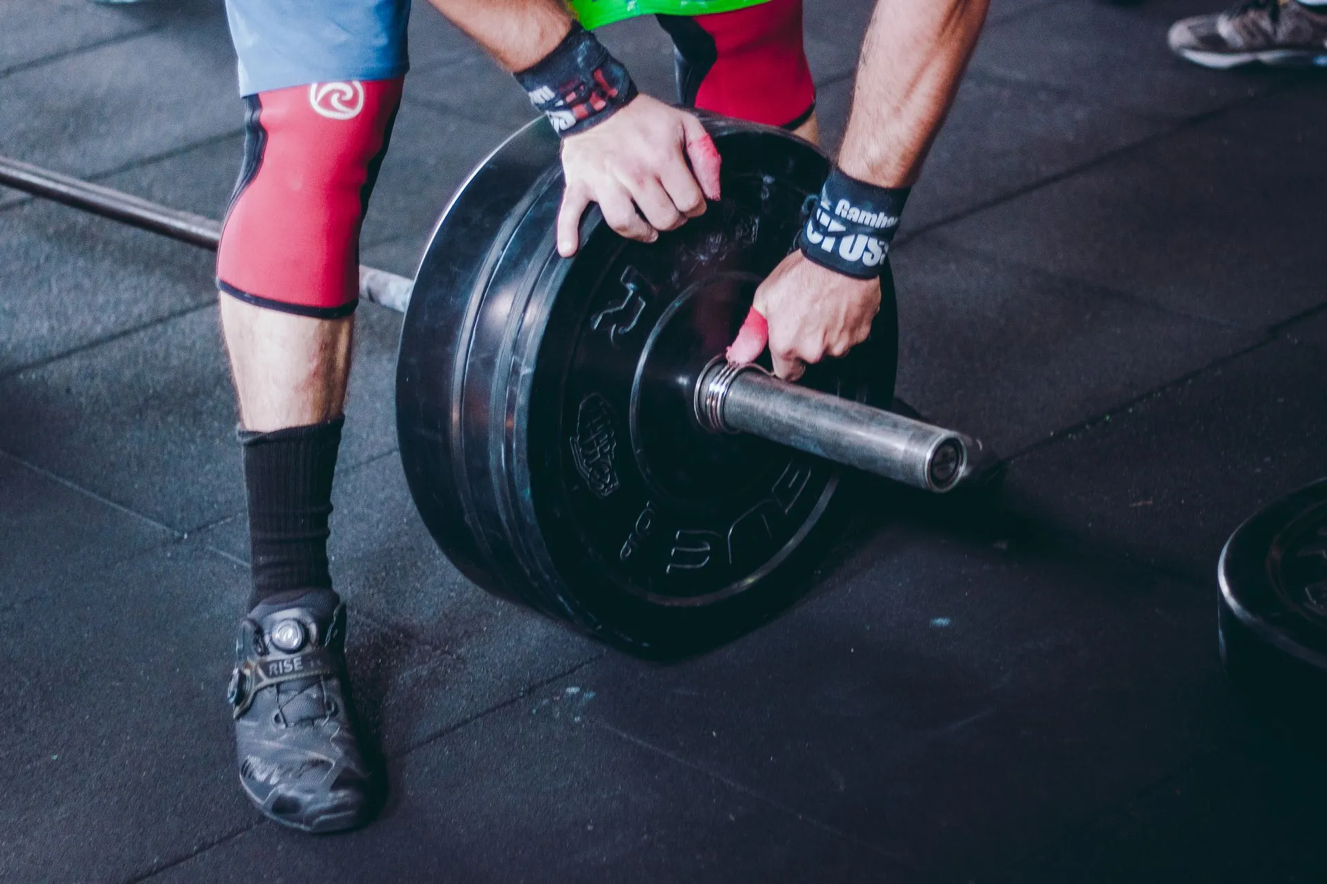 Knee Sleeves und Wraps neben der Langhantel in Nahaufnahme